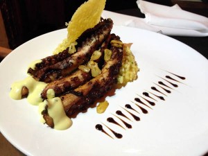 Polvo grelhado com lâminas de alho, ao molho dijón e risotto milanês.